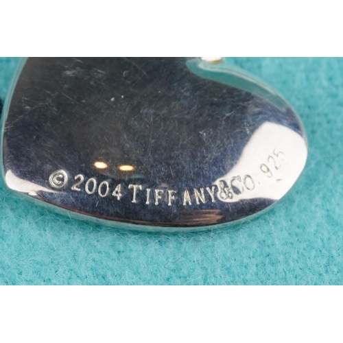 73 - A boxed Tiffany & Co silver heart shaped pendant on chain, the pendant with heart shaped hole stampe... 