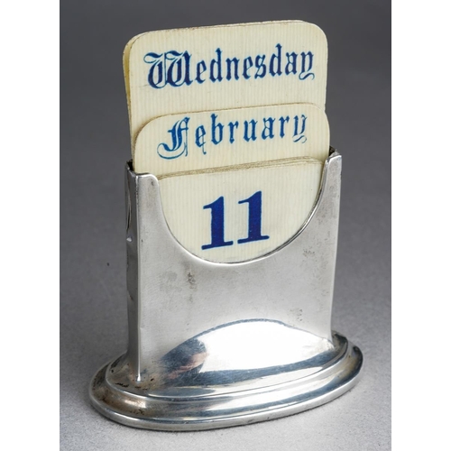 458 - A George V silver perpetual calendar of rectangular form on an oval loaded base, fitted with removab... 