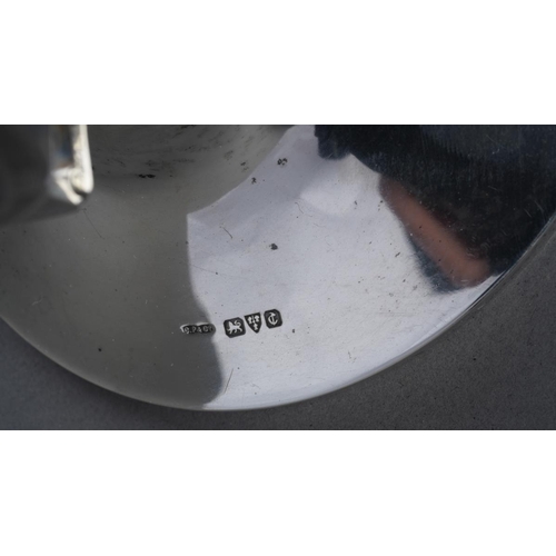 466 - A George V silver capstan inkwell, the hinged lid with engine turned decoration, glass liner, loaded... 