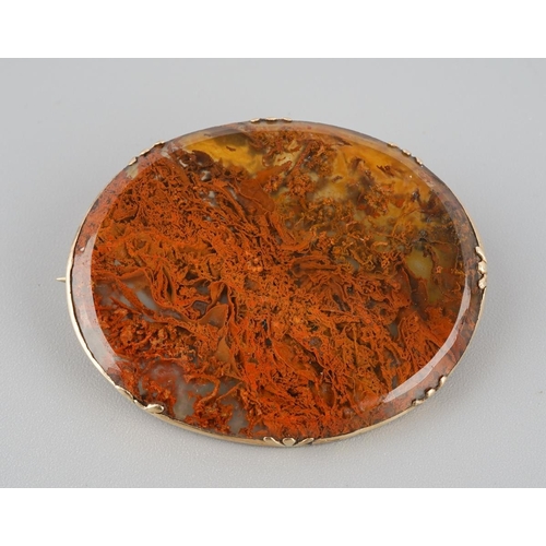 730 - An antique gold agate brooch. The moss agate panel, with a yellow metal surmount, mount unmarked, as... 