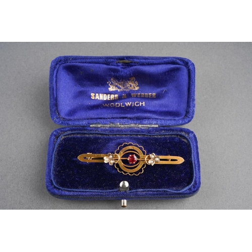 733 - An antique gem set brooch. Set with a garnet topped doublet and seed pearl accents, brooch assessed ... 