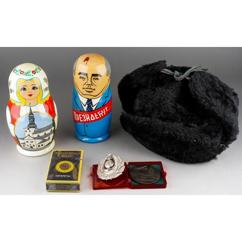 102 - Collection of various Russian related items to include two russian dolls, hat, unopened cigarete pac... 