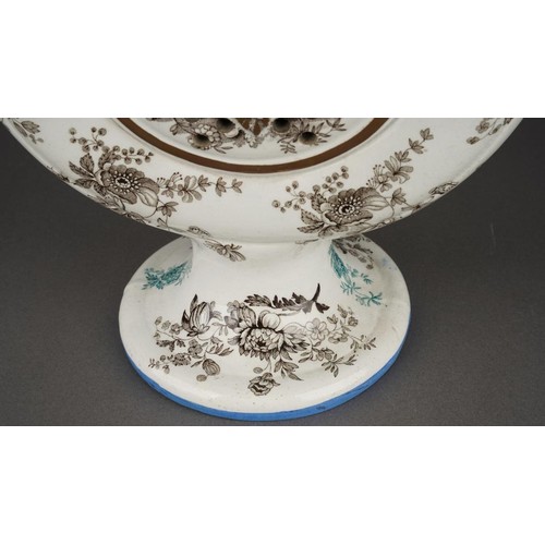 242 - An early 19th Century transfer printed puzzle jug, the circular flask form centred by a raised sun m... 