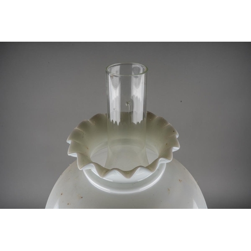 569 - An early 20th century brass based oil lamp, the white glass domed shade with frilled top, comes with... 