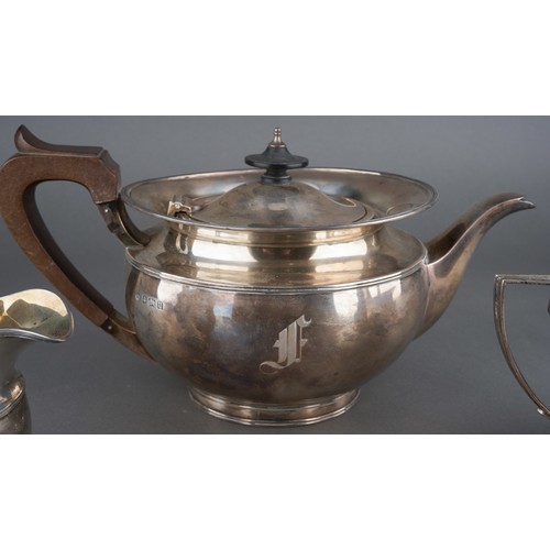 628 - A George V silver teaset comprising teapot with fruitwood handle and finial, milk jug and sugar bowl... 