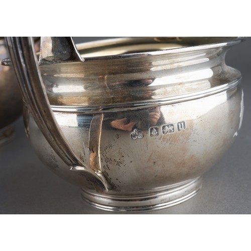 628 - A George V silver teaset comprising teapot with fruitwood handle and finial, milk jug and sugar bowl... 