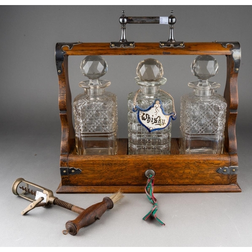 651 - A late 19th century Walker and Hall EPNS mounted oak tantalus, fitted with three square decanters, o... 