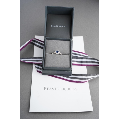 792 - An 18ct gold sapphire and diamond cluster ring. Hallmarked 18ct gold, sponsors mark Beaverbrooks, wi... 