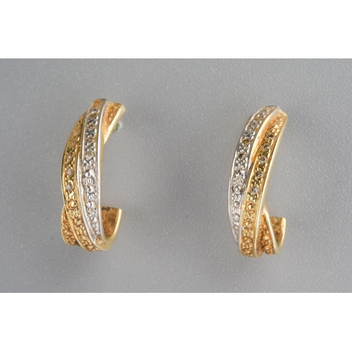 828 - A pair of diamond earrings. Each yellow and white cross over design ear hoop set with single cut dia... 