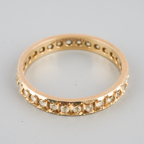 869 - A 9ct gold eternity ring. Set with synthetic white spinel, hallmarked 9ct gold, approx ring size N, ... 
