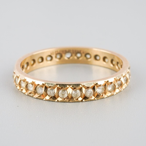 869 - A 9ct gold eternity ring. Set with synthetic white spinel, hallmarked 9ct gold, approx ring size N, ... 