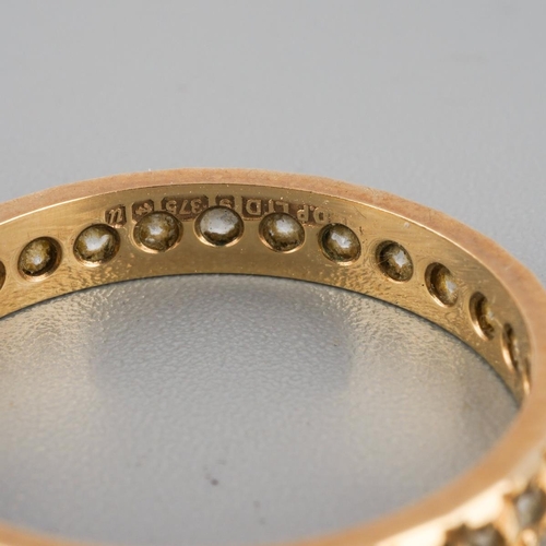 869 - A 9ct gold eternity ring. Set with synthetic white spinel, hallmarked 9ct gold, approx ring size N, ... 