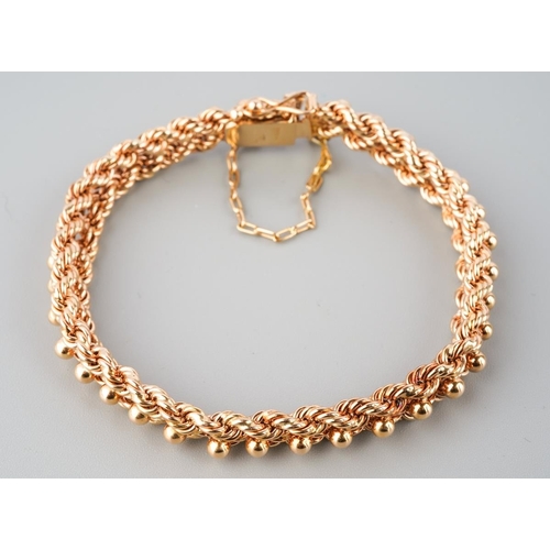 899 - A rose metal bracelet, stamped 18k. The fancy rope twist bracelet with push piece clasp and security... 