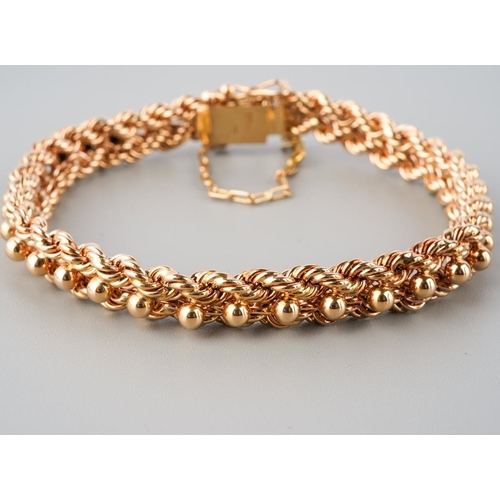 899 - A rose metal bracelet, stamped 18k. The fancy rope twist bracelet with push piece clasp and security... 