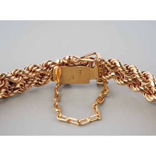 899 - A rose metal bracelet, stamped 18k. The fancy rope twist bracelet with push piece clasp and security... 
