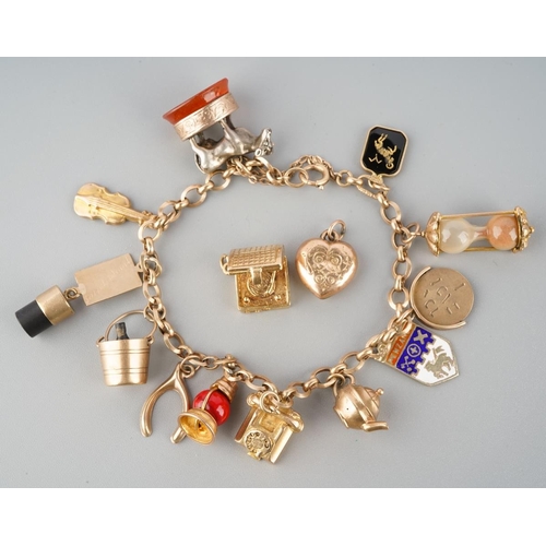 965 - An early to mid 20th century charm bracelet. The bracelet with spring clasp, suspending approx twelv... 