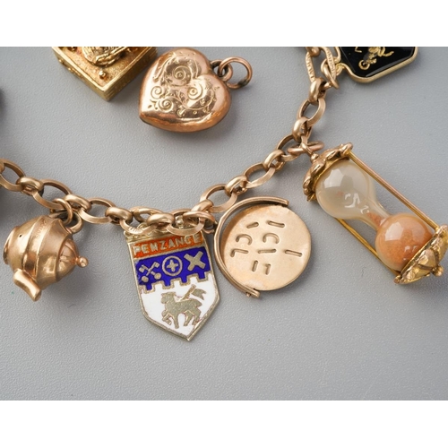 965 - An early to mid 20th century charm bracelet. The bracelet with spring clasp, suspending approx twelv... 