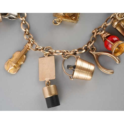 965 - An early to mid 20th century charm bracelet. The bracelet with spring clasp, suspending approx twelv... 