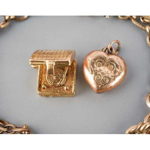 965 - An early to mid 20th century charm bracelet. The bracelet with spring clasp, suspending approx twelv... 