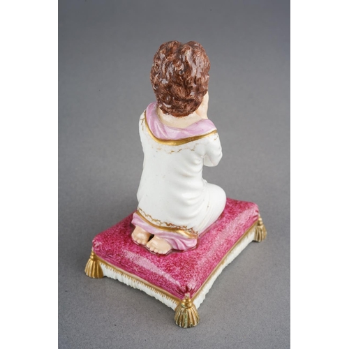 52 - A Bloor Derby figure of a young girl praying, circa 1825, on a puce cushion with gilt tassels, red p... 