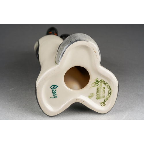 98 - A Moorcroft model of a Penguin family [two adults and chick], 2009 date cypher, printed and painted ... 