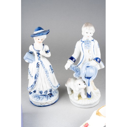 210 - A pair of continental 18th Century style blue and white figures, including boy and girl, the boy wit... 