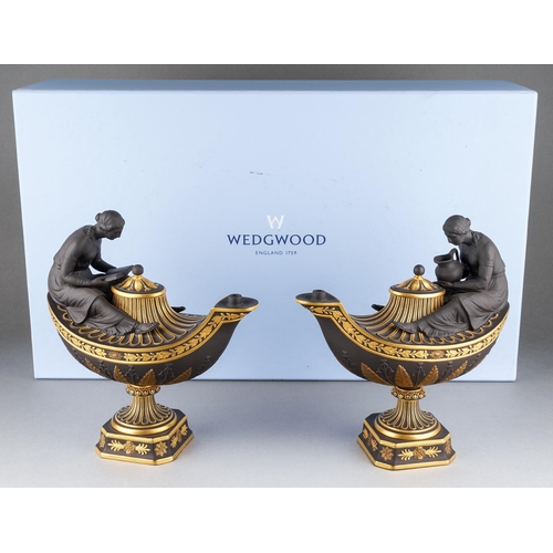 A boxed pair of modern Wedgwood black basalt and gilt "Vestal oil lamp and cover inspired from an original c.1775", one marked female figure with jug and the other marked  female figure with book, impressed and printed gilt marks, height 21.5cm approx (1)