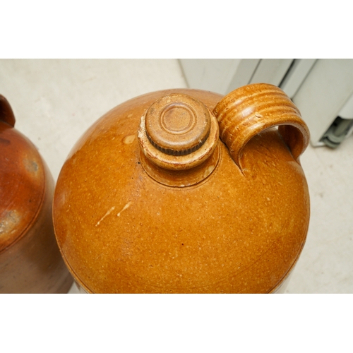 1 - A large stoneware storage flagon, the loop handle with thumb mark, approx 56cm tall and a smaller br... 