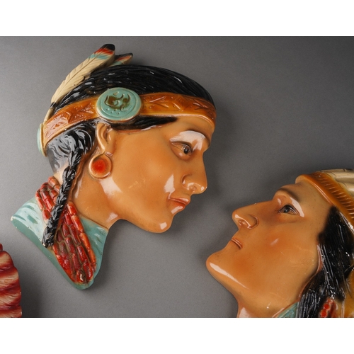 60 - Four mid-20th century wall masks of Native Americans, comprising a ceramic pair of male and female, ... 