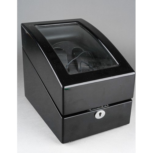 15 - A black finish automatic watch winding case for two watches, the glazed hinged sloped front enclosin... 
