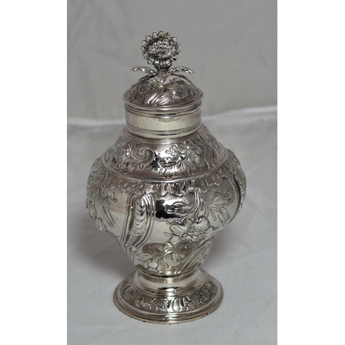 305 - A George II period silver tea caddy of baluster form raised on a circular foot, the sides chased wit... 