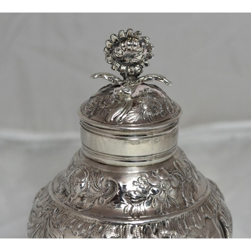 305 - A George II period silver tea caddy of baluster form raised on a circular foot, the sides chased wit... 