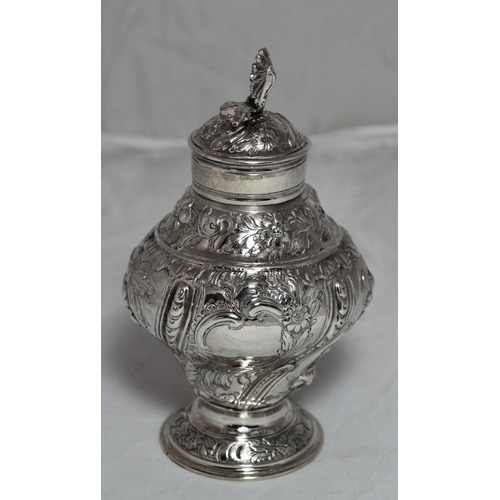 305 - A George II period silver tea caddy of baluster form raised on a circular foot, the sides chased wit... 