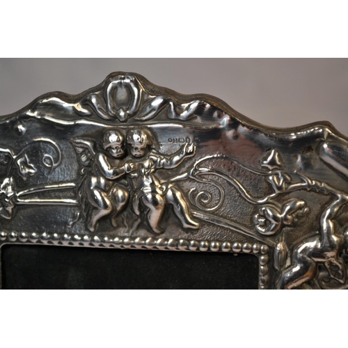 359 - A silver photograph frame decorated with cherubs - Birmingham 1997 by Ray Hall - approx 9