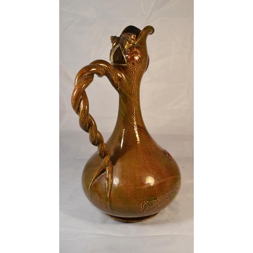 420 - An unusual grotesque pottery ewer with antique paper labels on the base. Approx 14