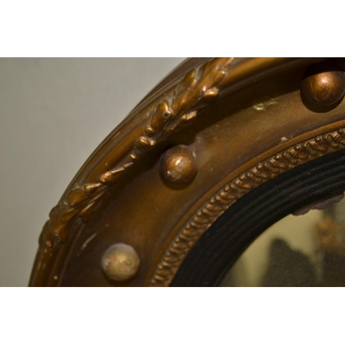 504 - An antique gilt convex wall mirror - 18