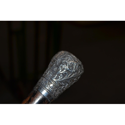 462 - An Indian white metal topped walking cane with embossed decoration c.1900