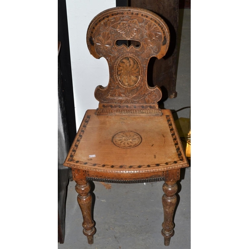 73 - A 19th century hall chair carved with Bacchanalian motifs.