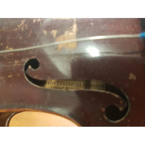 285 - An antique violin with a 2 piece back bearing a Stradivarius label - case and bow