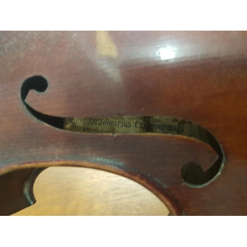 284 - An antique violin with a one piece back bearing a Stradivarius label - case and bow