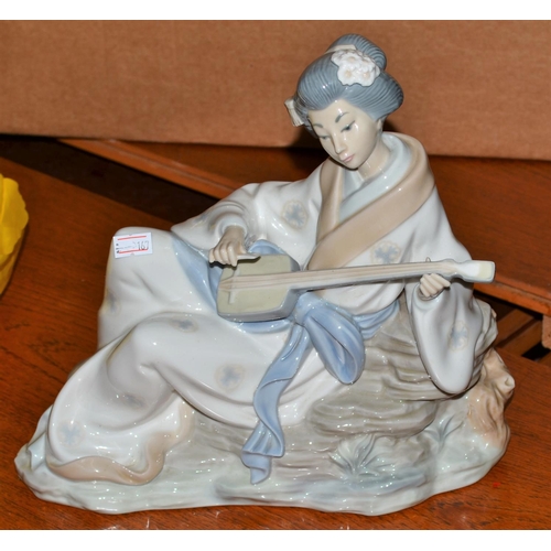 379 - A Nao figure of an Oriental lady playing a Shamisen