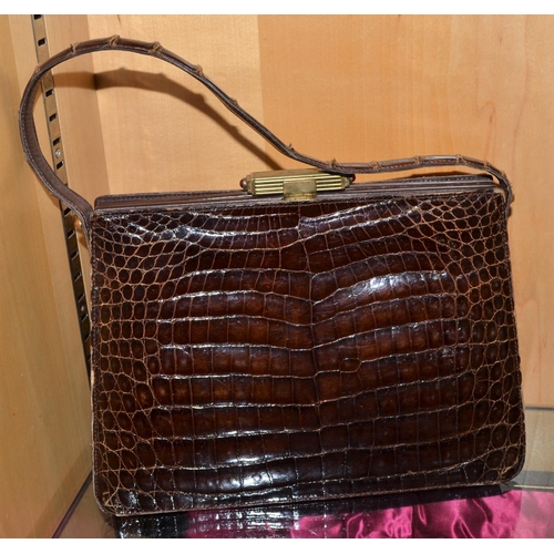 699 - An early 20th century Asprey of London Crocodile skin handbag with gilt metal clasp.