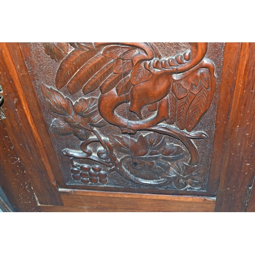 72 - An antique carved wooden corner cupboard with dragon motif