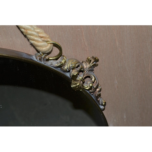 243 - A large round mirror with rope hanging and gilt metal mounts