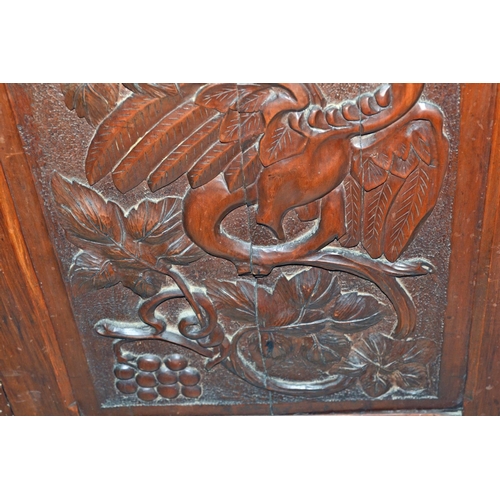 72 - An antique carved wooden corner cupboard with dragon motif