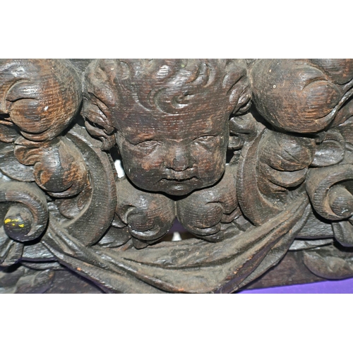 107 - An antique carved wooden frieze of cherubs etc