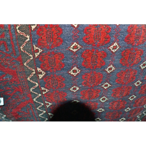 129 - A vintage red and blue ground rug