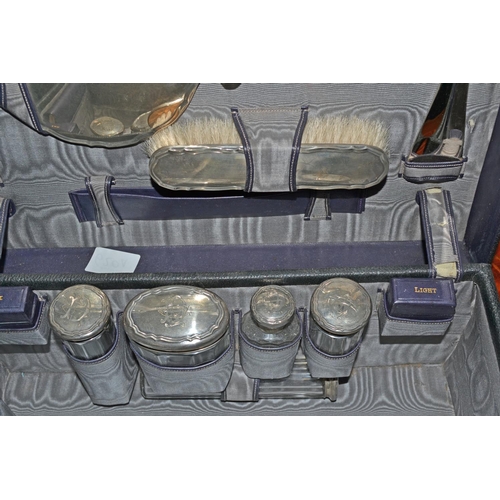 650a - A Moroccan leather travelling vanity case with silver mounted bottles etc to the interior. The whole... 