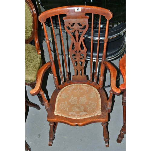 92 - An antique stick back rocking chair with fabric seat