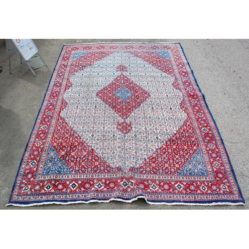 26 - A large red and blue ground rug with Herati border